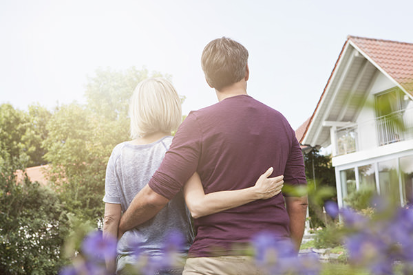 Couple in garden looking at house Couple in garden looking at house